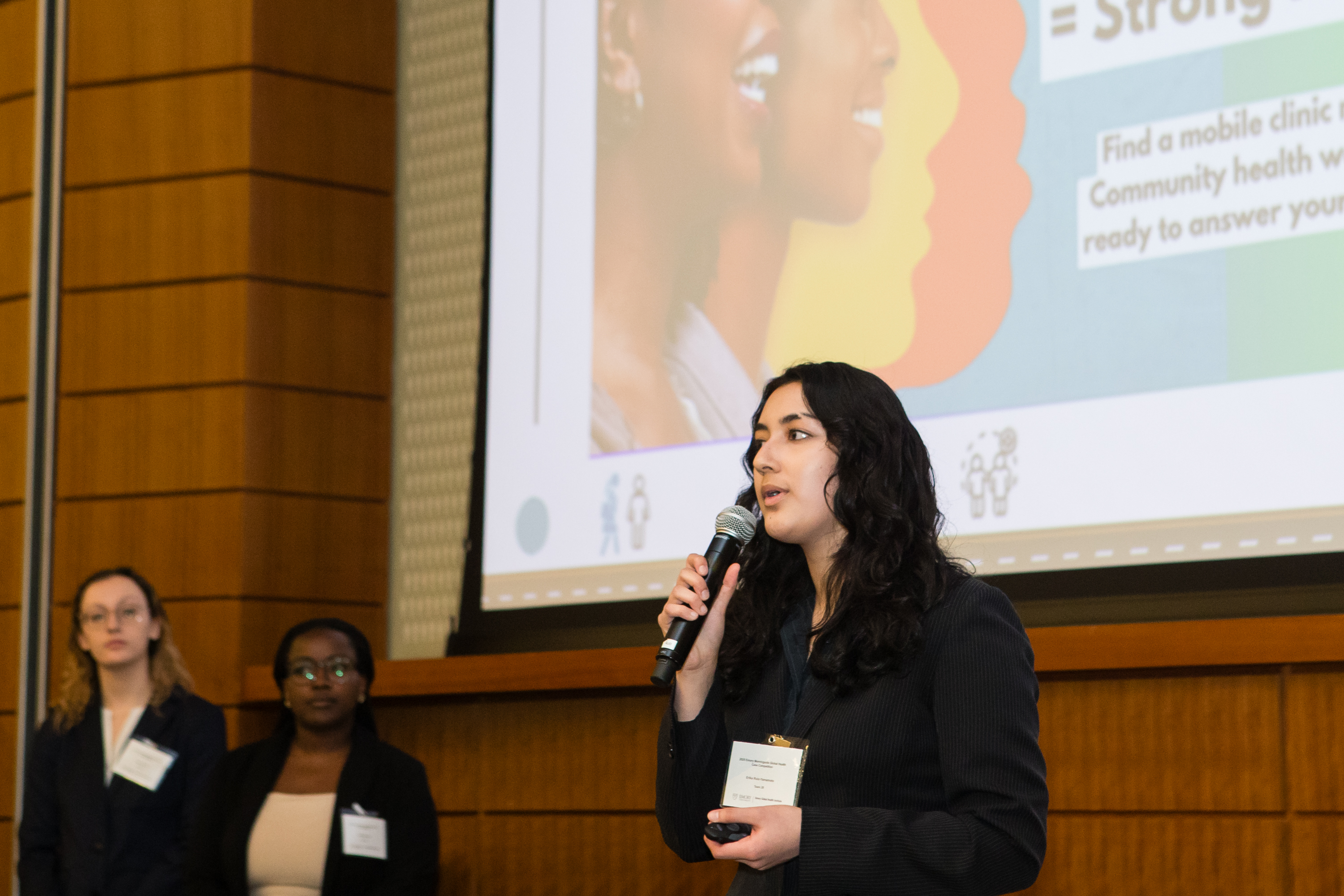 Erika Ruiz-Yamamoto holding a microphone and presenting